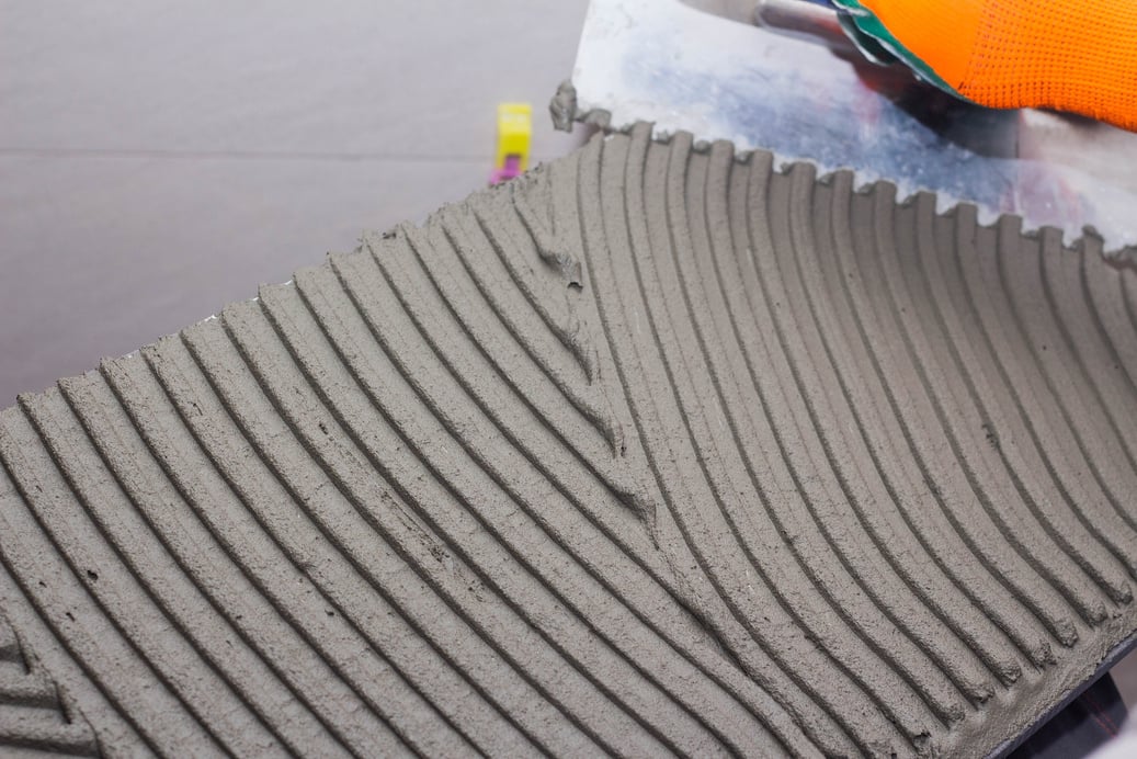 applying tile adhesive on tile